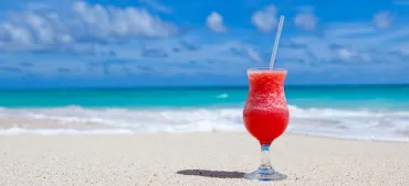 Rode cocktail op een zonnig strand
